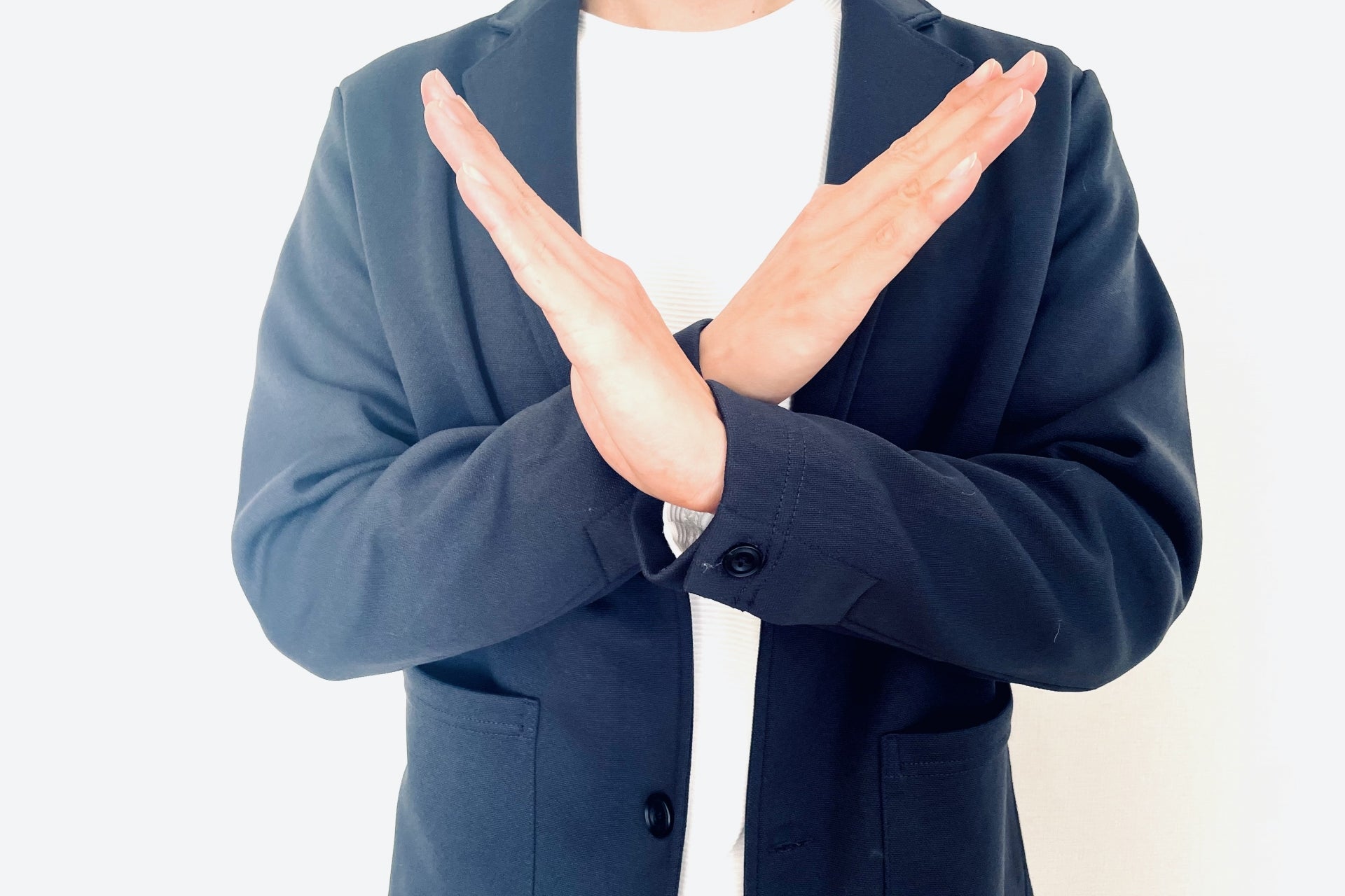 手でバツを作る若い男性