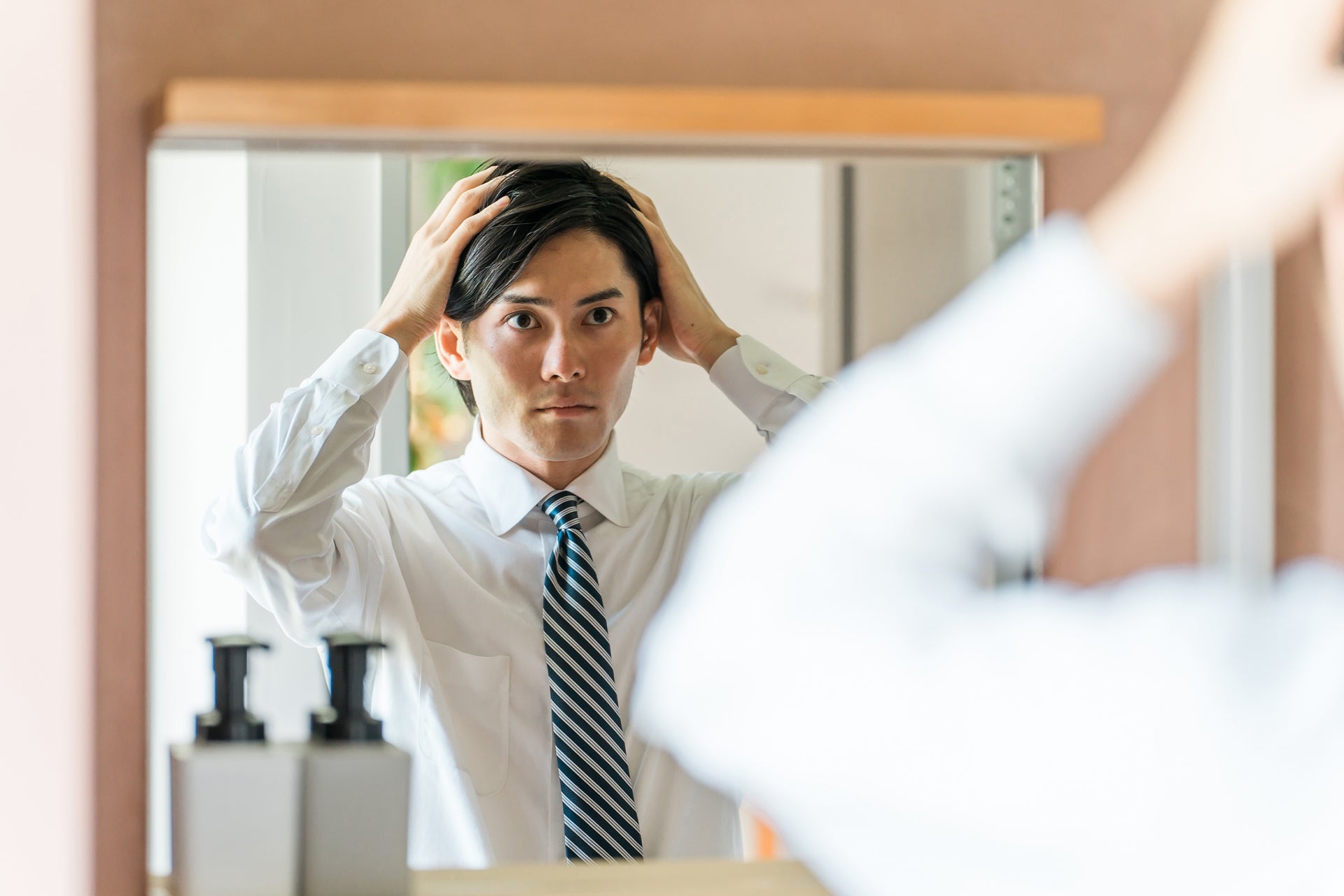 出勤前にヘアセットするビジネスマンの男性